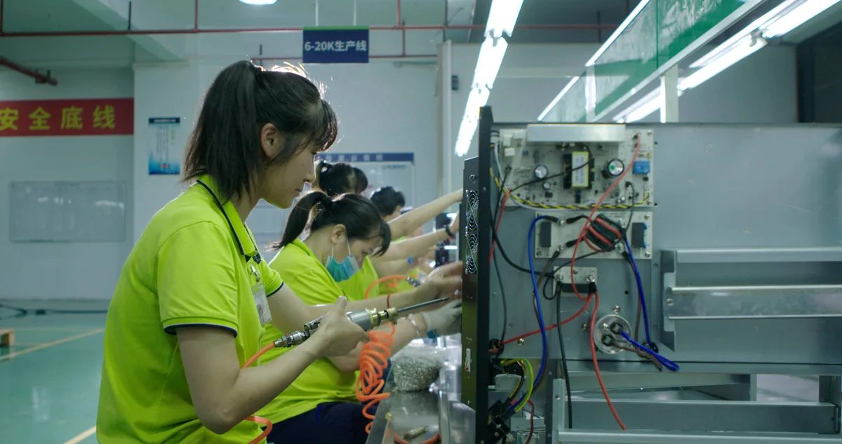 Technicians assembling UPS units along a workshop production line