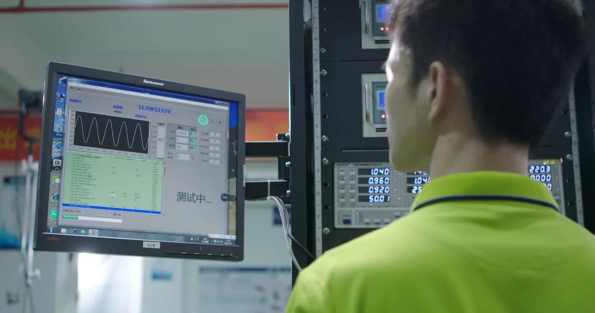 Technician monitoring a UPS functional test screen and instruments